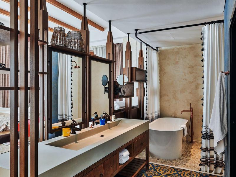 Modernes Badezimmer mit freistehender Badewanne, Doppelwaschbecken und natürlichen Holzakzenten.