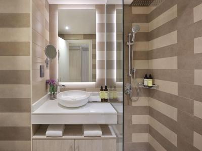 Nowoczesna łazienka z podświetlanym lustrem, umywalką i beżowymi paskowanymi płytkami