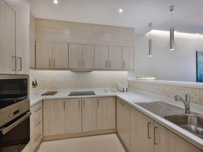 Para w letnich ubraniach spaceruje po tarasie z widokiem na wieżowce i wodę.