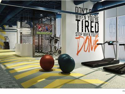 Hotel gym with treadmills, medicine balls, and a motivational wall quote.