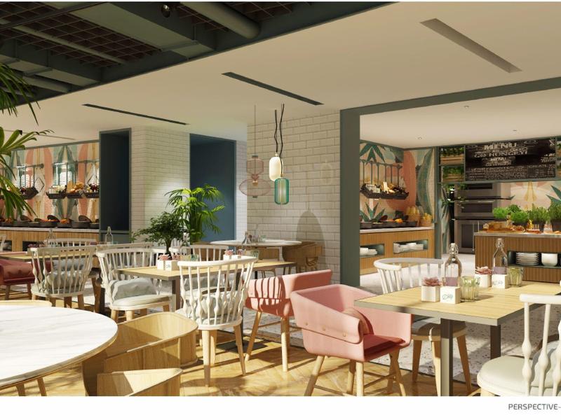 Helles Restaurant mit Holz- und weißen Möbeln, Pflanzen und großem Fenster für viel Tageslicht.