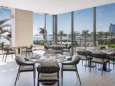 Nowoczesna jadalnia z panoramicznymi oknami z widokiem na palmy i miasto