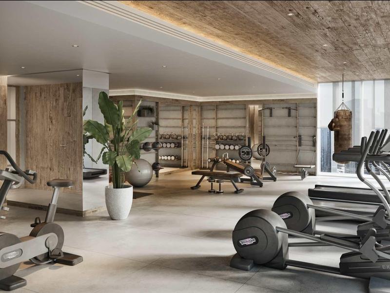 Moderner Speisesaal mit großen Fenstern, grauen Stühlen und Blick auf Palmen und Meer.