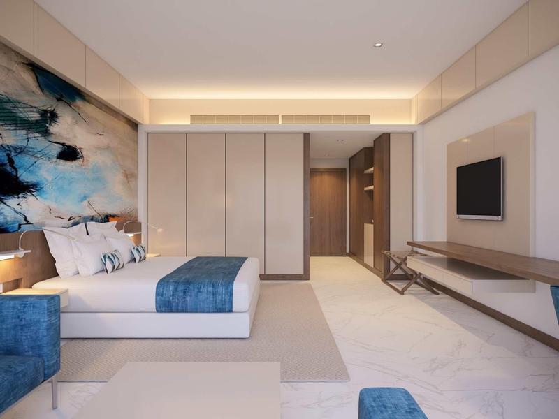 Modernes Schlafzimmer mit großem Bett, blauer Tagesdecke, Wandkunst und eingebautem Kleiderschrank.