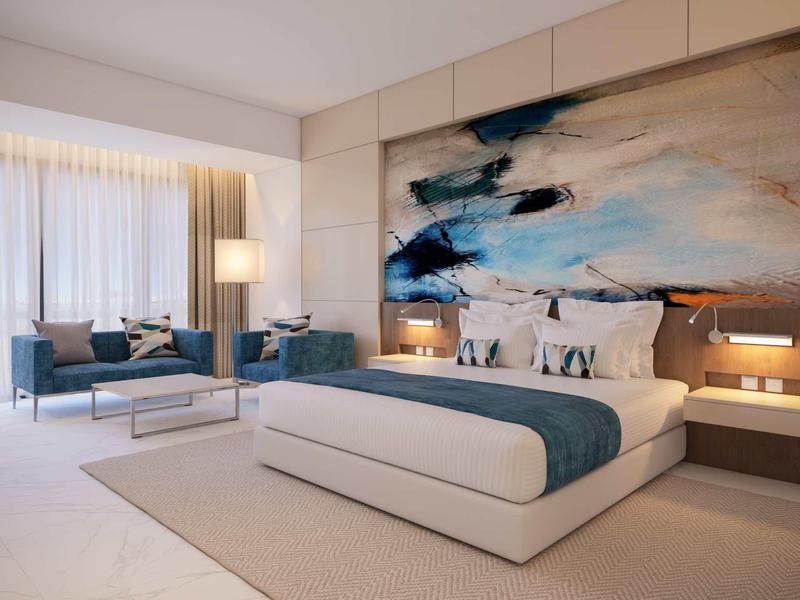 Modernes Schlafzimmer mit großem Bett, abstraktem Gemälde und elegantem Sitzbereich.