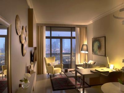 Moderna habitación de hotel con gran ventana, sillones y iluminación cálida, ambiente acogedor.