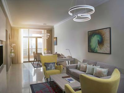 Sala luminosa con sillones amarillos, sofá gris y arte moderno en la pared.