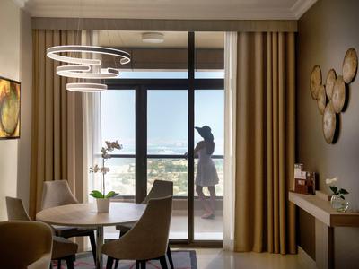 Área de comedor moderna con mesa, sillas y vista al balcón con vista al mar.