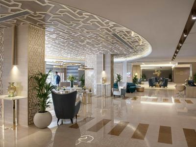 Área de lobby de hotel moderna con iluminación elegante y cómodas áreas de estar.