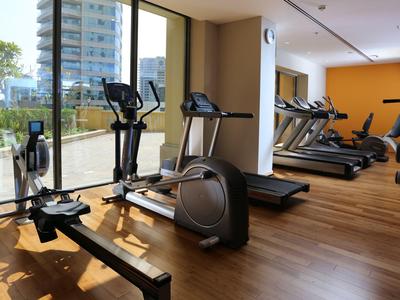 Palestra moderna con pavimento in legno e grandi finestre con vista esterna.