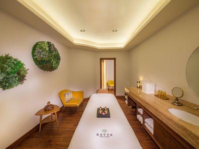 Elegante wellnessruimte met massagetafel, houten meubels en rustgevende verlichting.