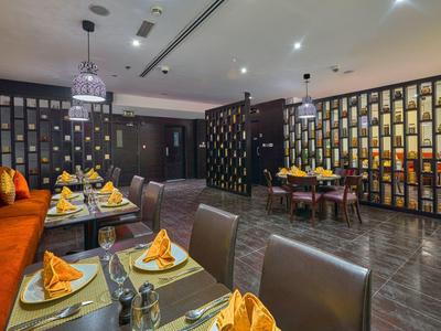 Moderní restaurace se stylovými stoly, oranžovými dekoracemi a teplou atmosférou.