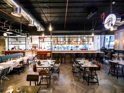 Modern restaurant with wooden tables, comfortable chairs, and stylish lighting.