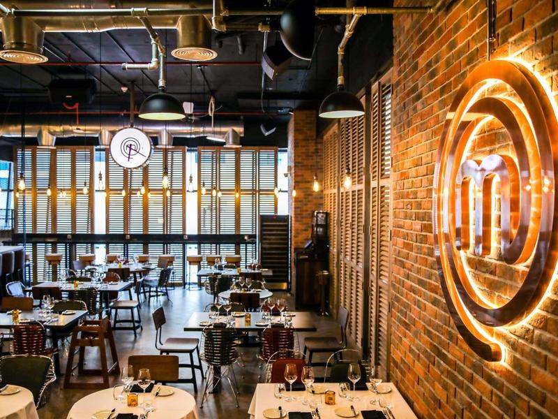 Modern restaurant with brick wall and illuminated round logo.