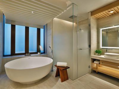 Modernes Badezimmer mit freistehender Badewanne, Glasdusche und beleuchtetem Spiegel