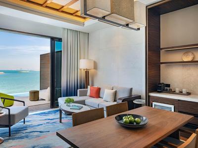 Moderner Wohnbereich mit Blick aufs Meer, mit Sitzgruppe, Esstisch und offener Küchenzeile.