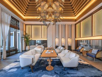 Eleganter Lounge-Bereich mit weißen Sesseln, blauen Teppichen und warmen Holz- und Deckenelementen