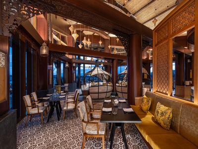 Elegantes Restaurant mit gemütlichen Sitzbereichen und warmem Holzinterieur.