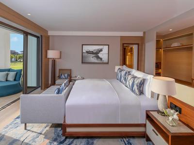 Modernes Hotelzimmer mit großer Glasschiebetür und Terrasse mit Sitzmöbeln