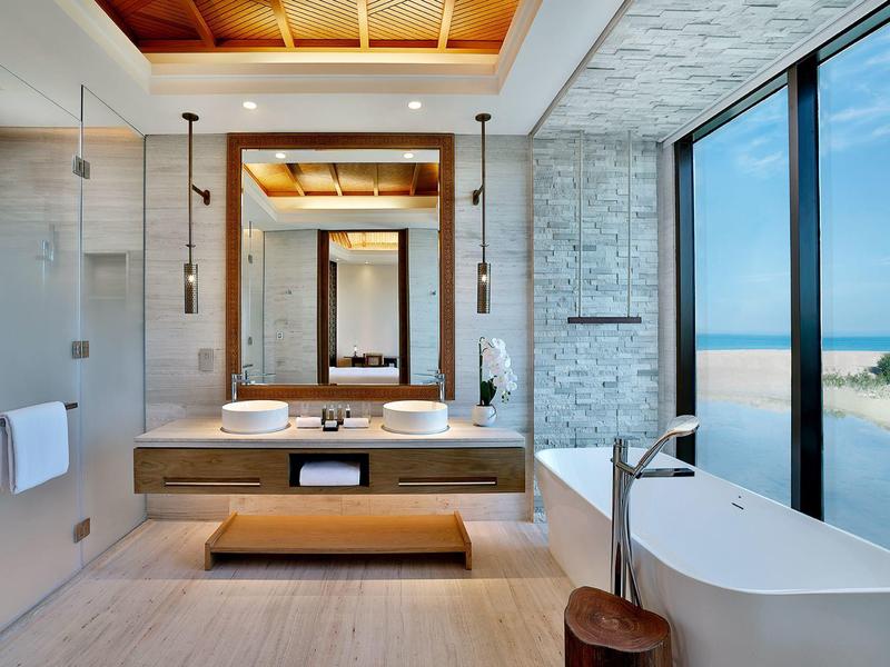 Modernes Badezimmer mit freistehender Badewanne und großem Fenster mit Meerblick