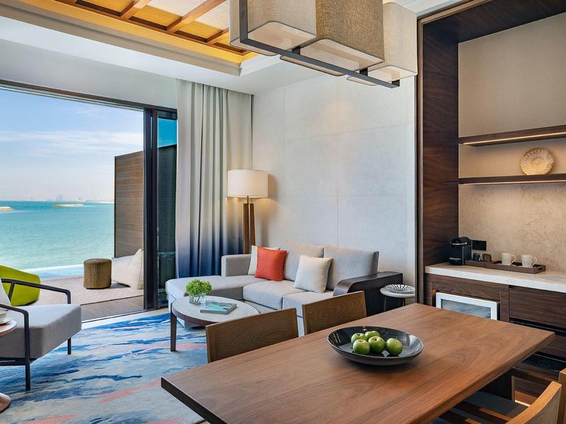 Moderner Wohnbereich mit Blick aufs Meer, mit Sitzgruppe, Esstisch und offener Küchenzeile.