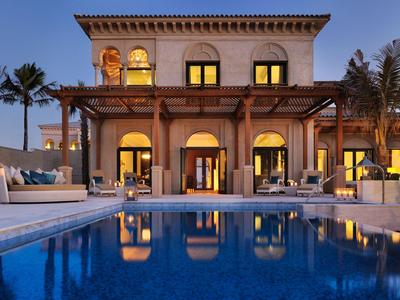 Luxury hotel with pool and tropical evening lighting.