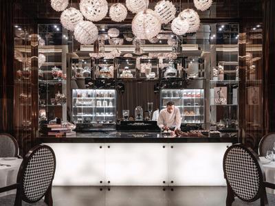 Elegante Bar mit beleuchtetem Tresen und dekorativen Lampen, Kellner hinter der Theke.