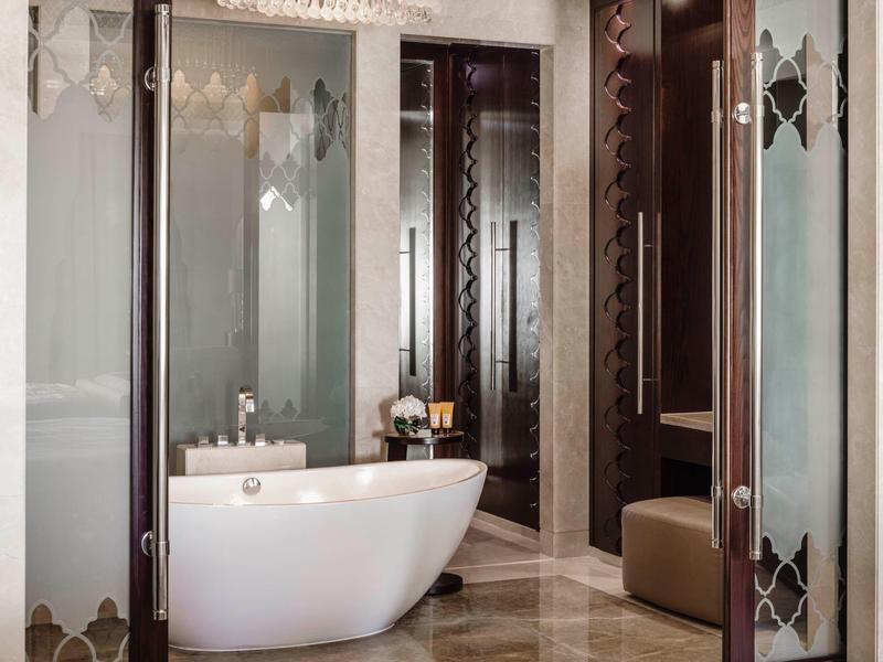 Modernes Badezimmer mit freistehender Badewanne und Glasduschkabine in warmen Tönen.