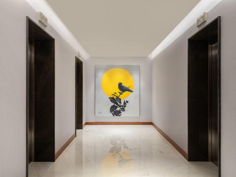 Flur mit weißen Wänden, zwei schwarzen Türen auf jeder Seite und Wandbild mit gelber Sonne und Vogel.