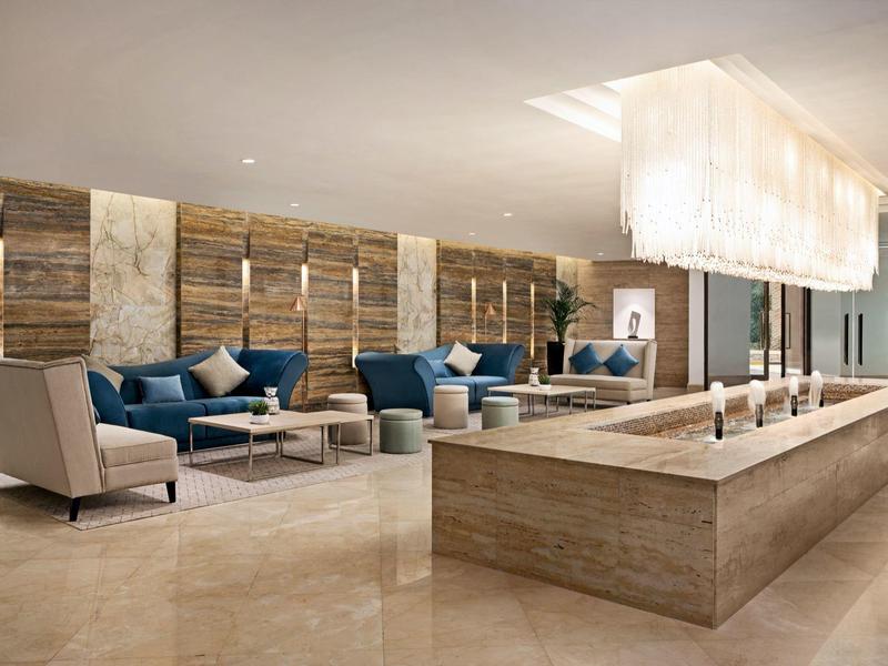 Moderner Hotel-Lobby mit Sitzbereichen, Marmorboden und stilvoller Beleuchtung.