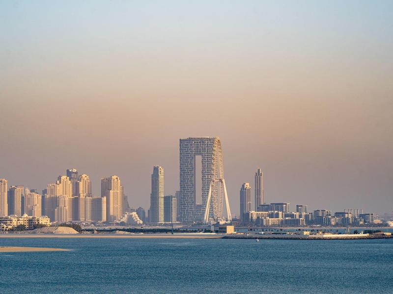 Stadtansicht mit modernen Wolkenkratzern am Wasser bei Sonnenuntergang.