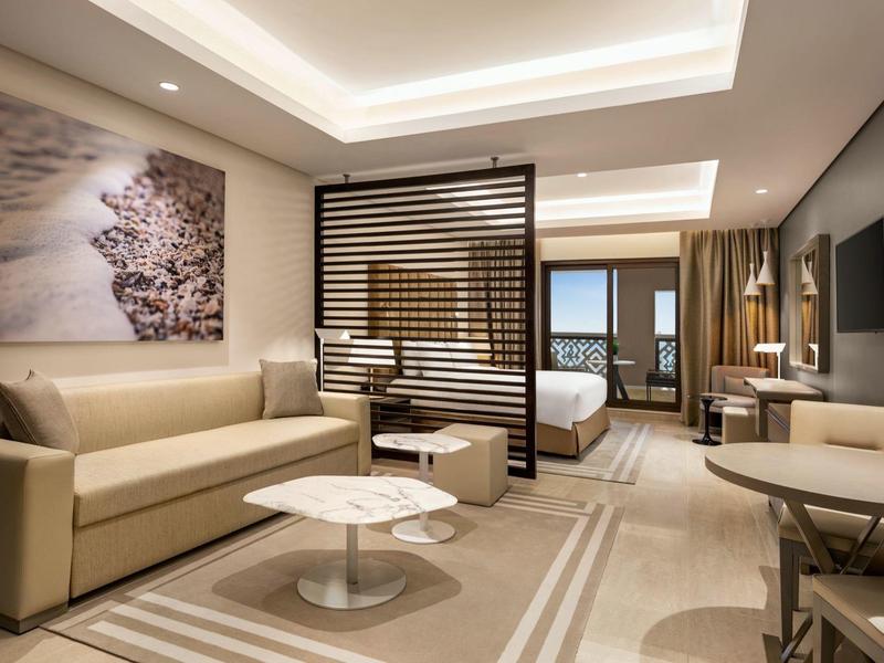 Modern eingerichtete Hotel-Suite mit Wohnzimmer, Schlafzimmer und Balkon