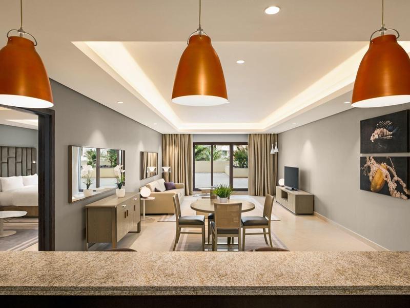 Modern eingerichtetes Wohnzimmer in einem Apartment mit Sitzbereich und Esstisch.