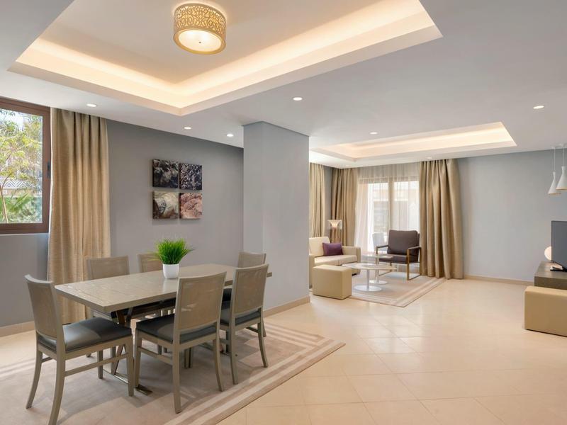 Moderner, offener Wohn- und Essbereich mit grauen Wänden und großen Fenstern.