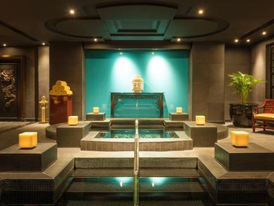 Luxe spa met zwembad, kaarsen en sfeerverlichting in een rustige omgeving.