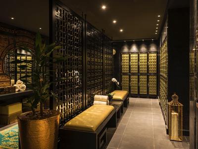 Luxe wijnkelder met zwarte metalen rekken, warme verlichting en beklede banken.
