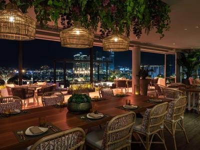 Elegancka, otwarta restauracja z widokiem na miasto nocą.