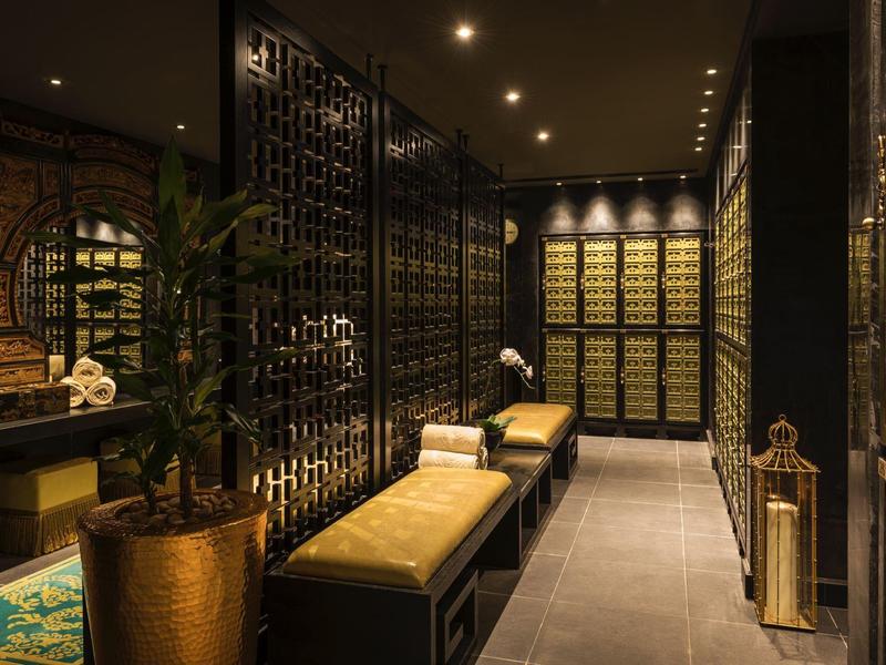 Luxe wijnkelder met zwarte metalen rekken, warme verlichting en beklede banken.