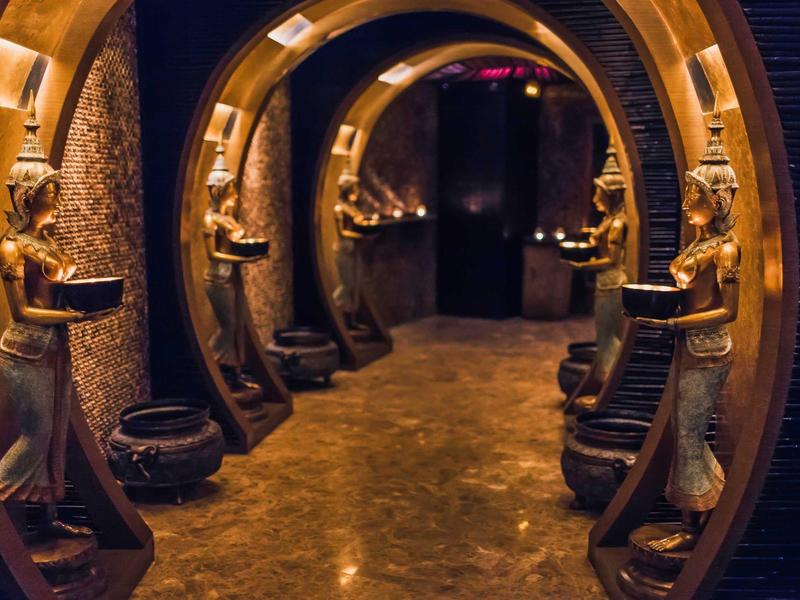 A decorative hallway with Egyptian statues and warm lighting in a hotel corridor.