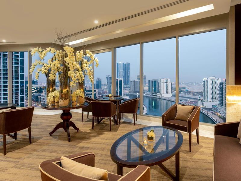 Elegant hotel lounge area with large windows overlooking a modern cityscape.
