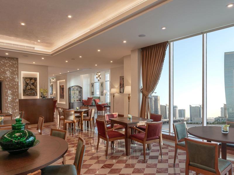 Elegant hotel dining area with large windows and city views