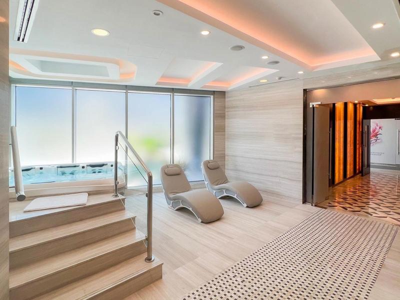 Modern wellness area with stairs, loungers, and large windows overlooking the water.