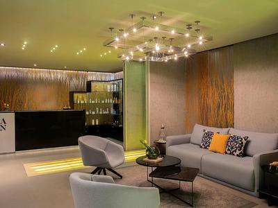 Moderne Hotellounge mit bequemen Sesseln, Sofa und stilvoller Beleuchtung.