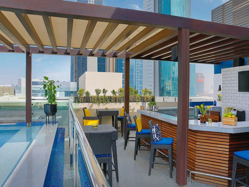 Moderne Dachterrasse mit Bar, Sitzgelegenheiten und Blick auf die Stadt