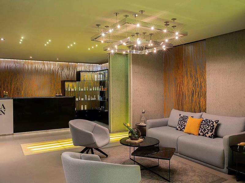 Moderne Hotellounge mit bequemen Sesseln, Sofa und stilvoller Beleuchtung.