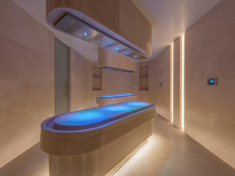 Moderne spa ruimte met verlicht behandeltafel in warme, minimalistische ruimte met zachte verlichting.