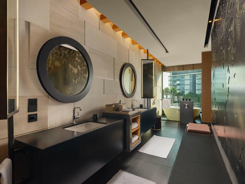 Moderne hotelbadkamer met twee wasbakken, grote spiegels en stijlvolle verlichting.