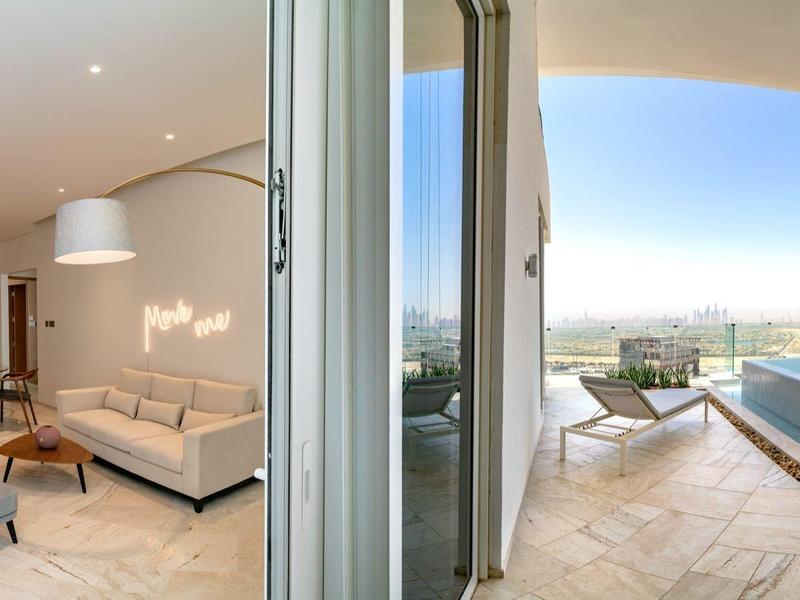 Moderne woonkamer met gezellige stoelen en bank, grenzend aan terras met zwembad en uitzicht.