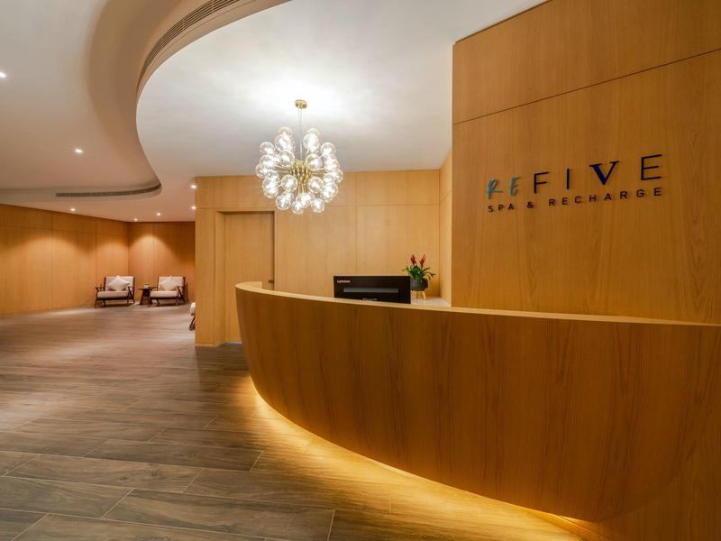 Elegante hotelreceptie met houten balie en moderne verlichting.