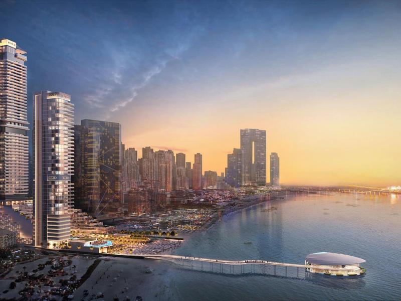 Urban coastline with modern skyscrapers at sunset by the water.